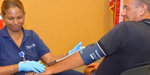 Mount Sinai Medical Center worker checking man's blood pressure