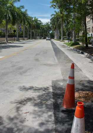 A photo of 172nd Street with 2 orange work cones placed in the foreground.