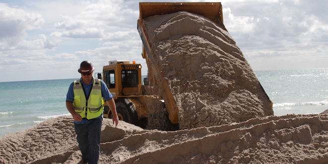 Dumptruck dumps sand on the beach during the Beach Sand Renourishment Project.