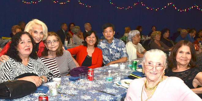 SIB Residents smile for the camera while sitting at a table at the City's Holiday Ball Party.