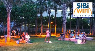 People sitting on benches in Samson Oceanfront Park during the evening and at superimposed SIB WiFi graphic in the corner.