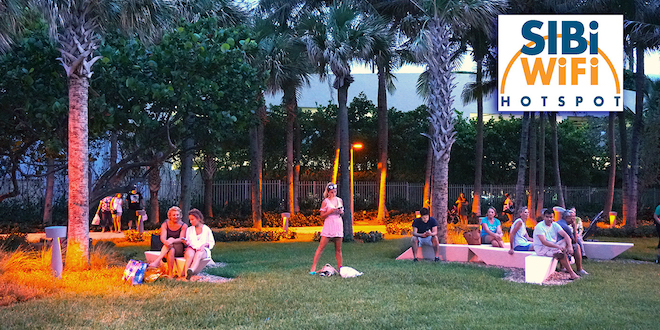 People sitting on benches in Samson Oceanfront Park during the evening and at superimposed SIB WiFi graphic in the corner.