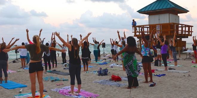 Yoga class participants on practicing on the beach.