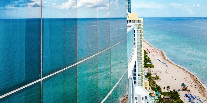 Building Reflecting Ocean in Side Glass Paneling