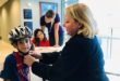 Sandra Block fits a young boy with a free bicycle helmet.