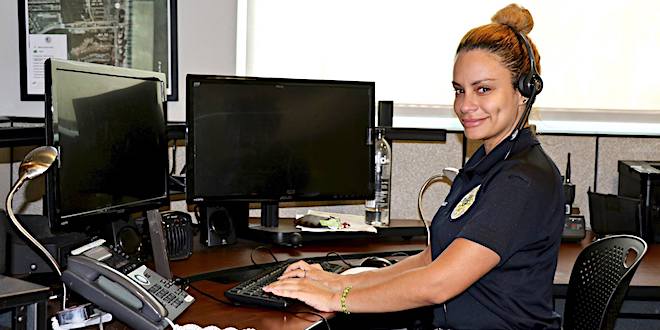 Sunny Isles Beach Police dispatch communications officer at her computer with headset on.