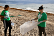 Volunteers cleaning up trash on the beach during a Sunny Isles Beach Beach Cleanup event