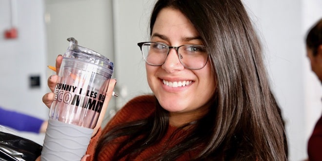Employee holding an ecommitted reusable cup