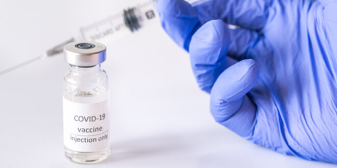 Hand holding needle for coronavirus vaccine