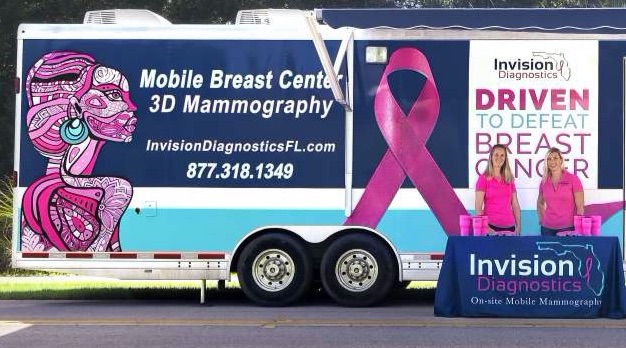 3D Mammogram mobile unit with pink ribbon and breast cancer messaging on side.